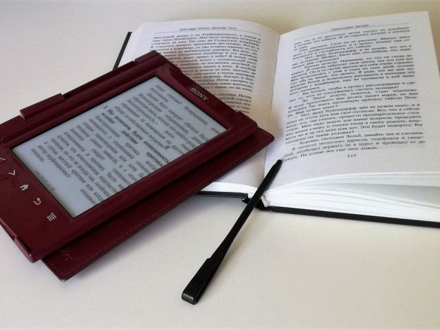 urządzenie do czytania ebooków położone na otwartej książce