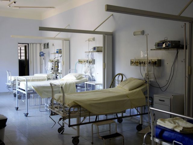 szpitalna sala chorych na zdjęciu łóżka szpitalane puste