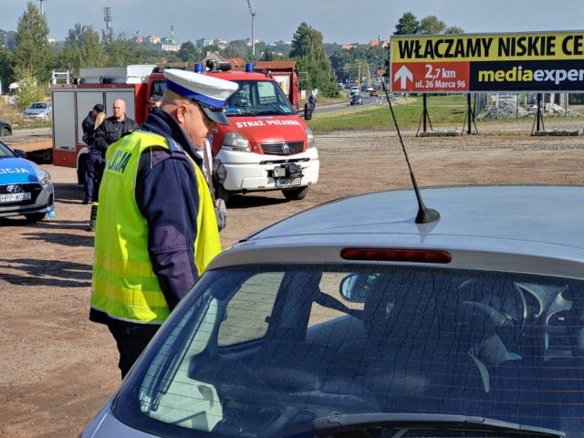 akcja Road Safety Days w Wodzisławiu Śl. 21 wrzesnia 2021, na zdjęciu policjant zatrzymujący samochód i tłumaczący powody zatrzymania