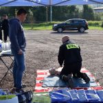 akcja Road Safety Days w Wodzisławiu Śl. 21 wrzesnia 2021, na zdjęciu kierowca oglądający instruktaż strażaka dotyczący udzielania pierwszej pomocy