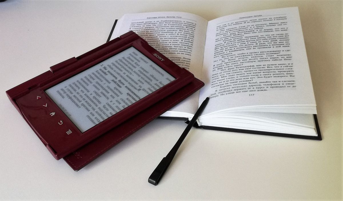 urządzenie do czytania ebooków położone na otwartej książce