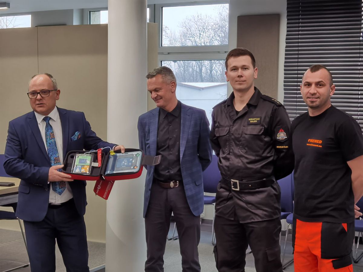 Od lewej starosta Leszek Bizoń, sekretrz Michał Lorek, Sebastian Bauer oraz Mateusz Kaczmarek ze straży pożarnej, prezentujący wszystkim defibrylator