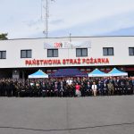 Zdjęcie grupowe uczestników apelu na dziedzińcu komendy PSP w Wodzisławiu Śl. z okazji Dnia Strażaka 2022 - zdjęcie z daleka całej grupy uczestników