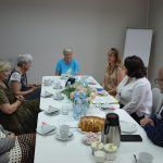 Spotkanie PSR Osob Niepelnosprawnych w Wodzislawiu Sl. Uczestnicy siedzący wokół stołu