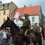 Inscenizacja historyczna. Rotmistrz siedzi na koniu a w ręku trzyma akt przyłączenia Górnego Śląska do Polski