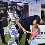 Policjanci z KPP w Wodzisławiu Śląskim wręczający materiały profilaktycze dziewczynce