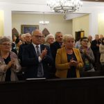Uczestnicy koncertu stoją i biją brawa. Z przodu starosta L. Bizoń i członek zarządu K. Kuczera.