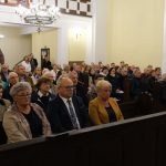 Uczestnicy koncertu siedzą w kościelnych ławkach. Z przodu starosta L. Bizoń i członek zarządu K. Kuczera.
