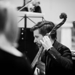 Krzysztof Firlus gra na viola da gamba. Zdjęcie jest czarno-białe.