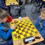 Chłopcy w wieku ok. 10 lat grają w szachy.