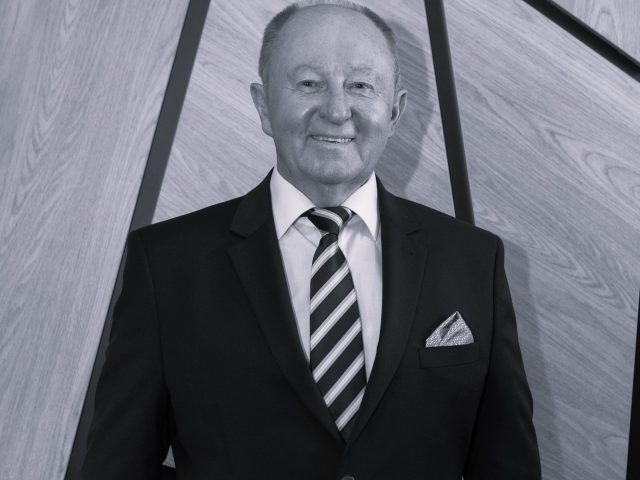 zdjęcie portretowe Tadeusza Skatuły, stoi, uśmiecha się, zdjęcie czarno-białe