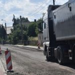ul. 3 Maja w Syryni, zdjęta nawierzchnia, z boku pachołek, przez drogę przejeżdża ciężarówka