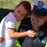 Chłopczyk przytula się do policjanta, uśmiechają się