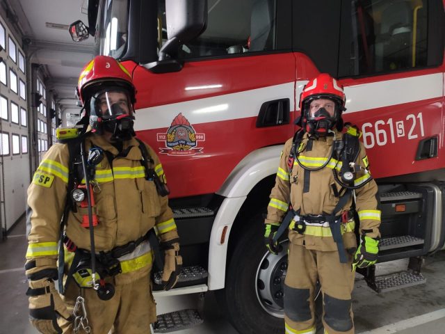 Dwóch strażaków ubranych w aparaty oddechowe