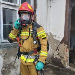 Strażak a aparacie tlenowym i stroju bojowym odpinającym maskę