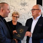 Dyrektor Caritas i starosta wodzisławski gratulują sobie i przekazują umowę o współpracy