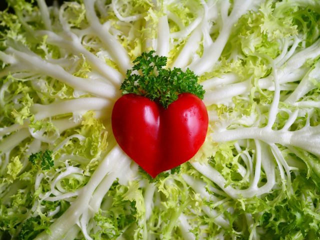zdjęcie kompozycji artystycznej złożonej z sałaty i czerwonej papryczki w kształcie serca